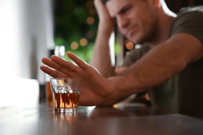 Man refusing a glass of alcohol